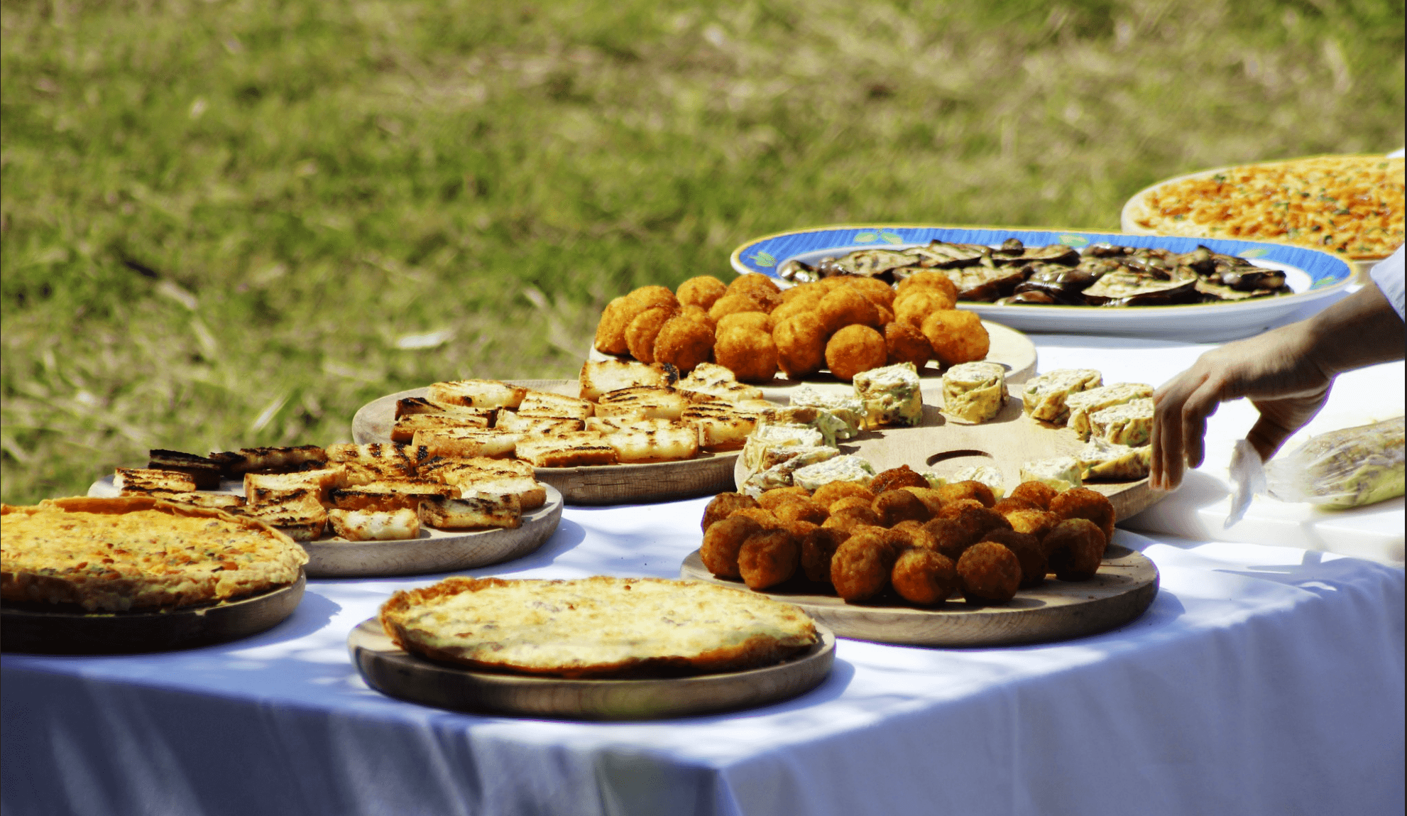 Photo of a picnic table with several dishes of food.