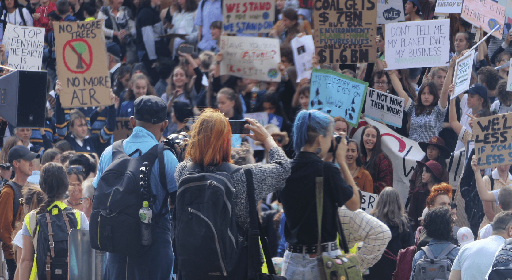 Diverse young people with mobile phones at a climate action rally represent the rising generation of shoppers and marketers.